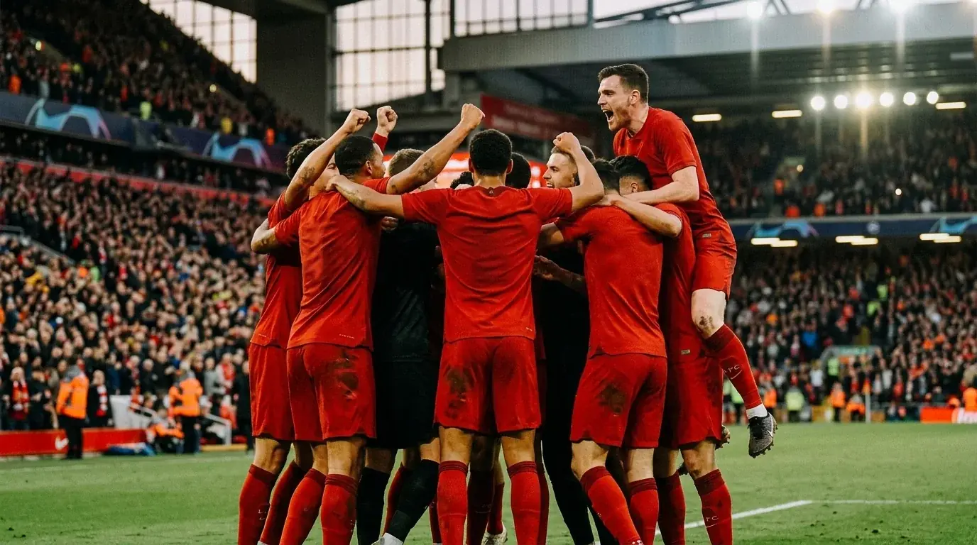 A soccer team in red celebrating together after a penalty shootout win in a packed stadium